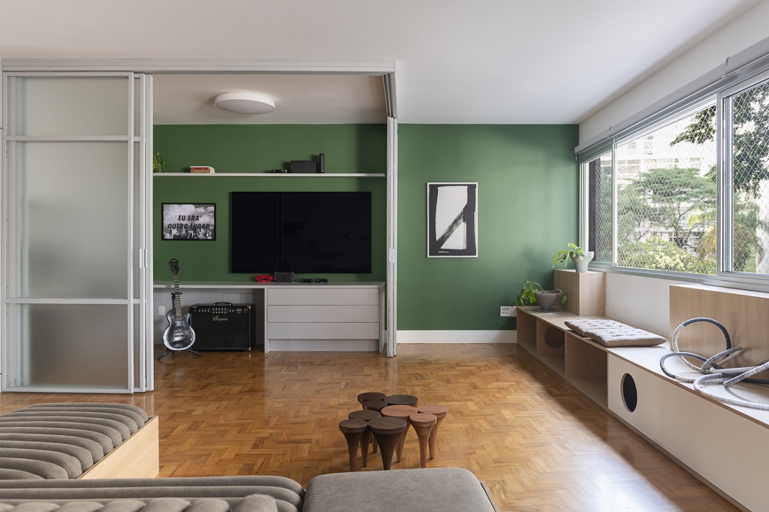 home office integrado à sala, onde banco e sofá foram pensados para acesso dos cães e gatos