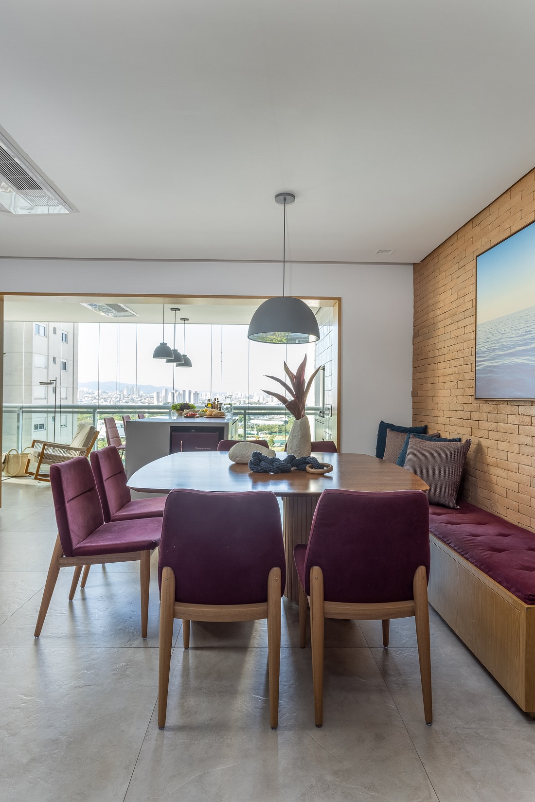 sala de jantar com cadeiras coloridas e banco estofado